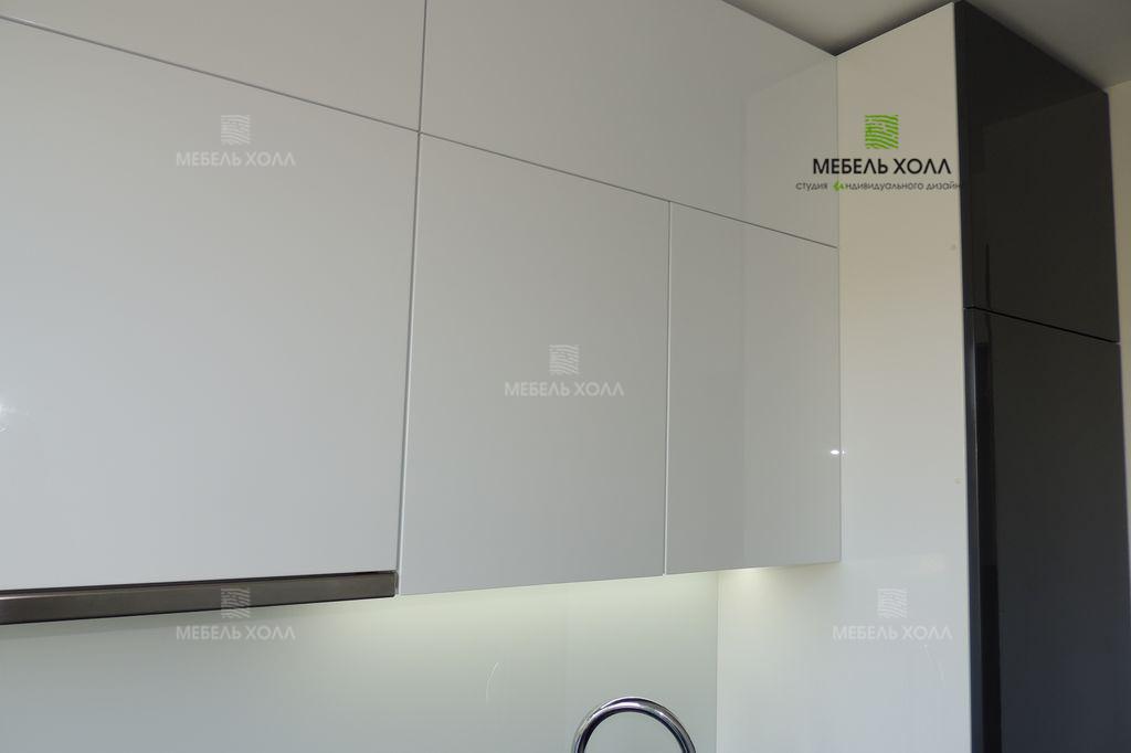 Компактная угловая кухня для маленького помещения из крашенного в белый и серый цвет МДФ. Столешница из акрила. Фурнитура Blum