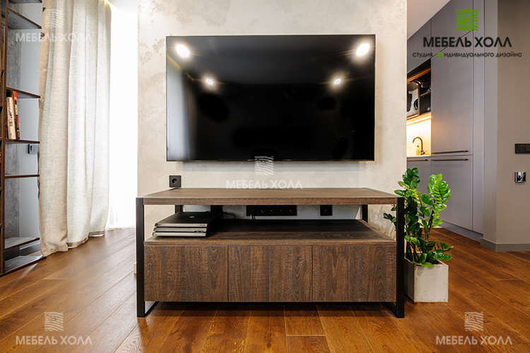 Низкий универсальный гарнитур под TV выполнен из Cleaf в темно-коричневых тонах и черных металлических опор.
