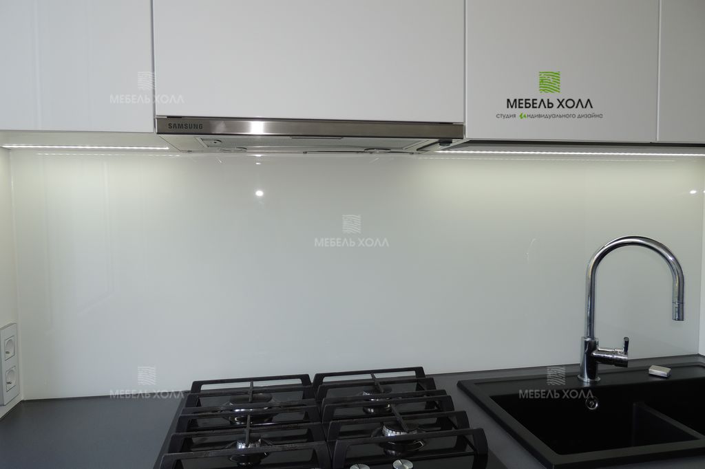 Компактная угловая кухня для маленького помещения из крашенного в белый и серый цвет МДФ. Столешница из акрила. Фурнитура Blum