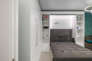 Встраиваемое спальное место из ЛДСП Egger с мягким изголовьем, шкафами для одежды и стеллажами. Размер 140х200 см
