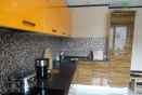 Современная угловая кухня с фасадами из МДФ покрытыми глянцем и шпоном. 