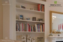 Встроенный книжный шкаф выполнен в белом цвете из МДФ и дверцами с декоративной решеткой 