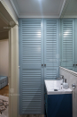 Мебель для ванной: зашивка коммуникаций и хозяйственный шкаф с жалюзийными фасадами из крашенного МДФ