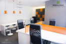 Офисная мебель из ДСП белого и оранжевого цветов. Помимо офисных столов и тумб в набор входит встроенный шкаф и полки для хранения 