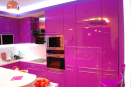 Яркая кухня малинового цвета из ламинированного ДСП с секциями из стекла в алюминиевом профиле. 